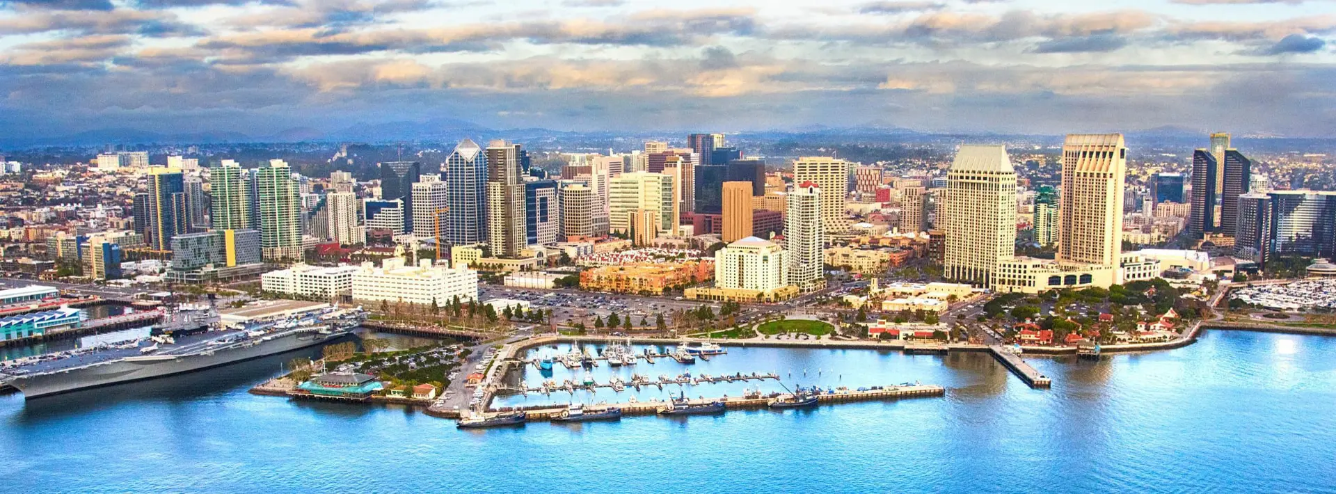 Aerial view of the downtown San Diego skyline and harbor at sunset with commercial office towers